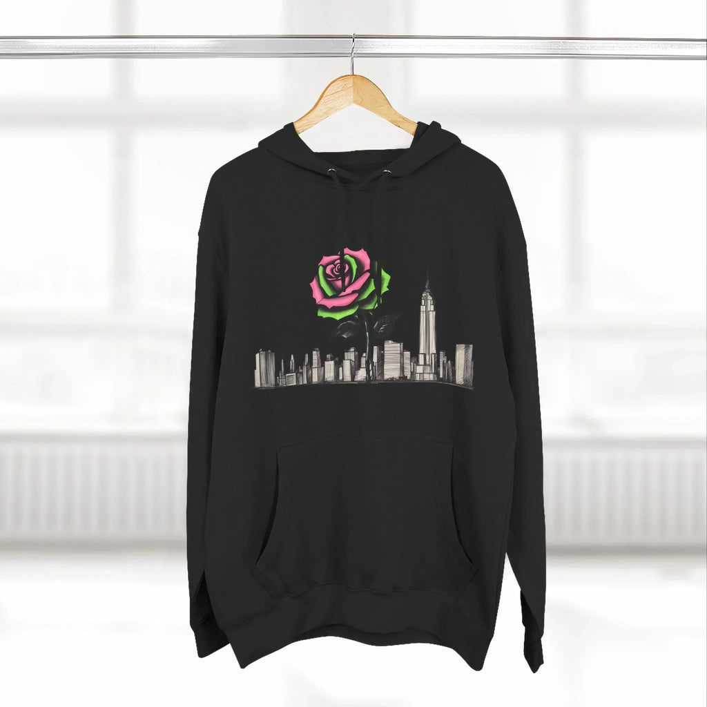 Black hoodie with New York skyline and colorful rose graphic, hanging on wooden hanger