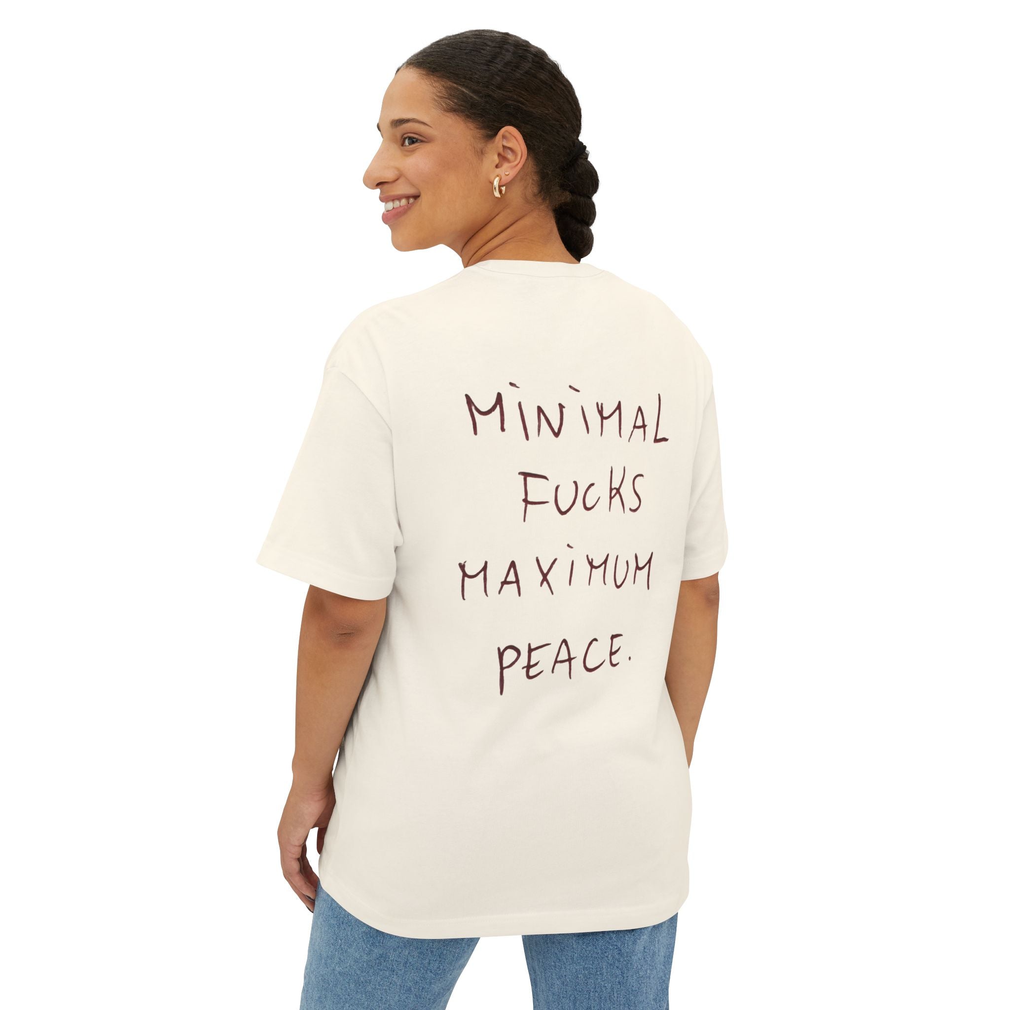 White oversized t-shirt with 'Minimal Fucks Maximum Peace' text graphic on back, worn by woman