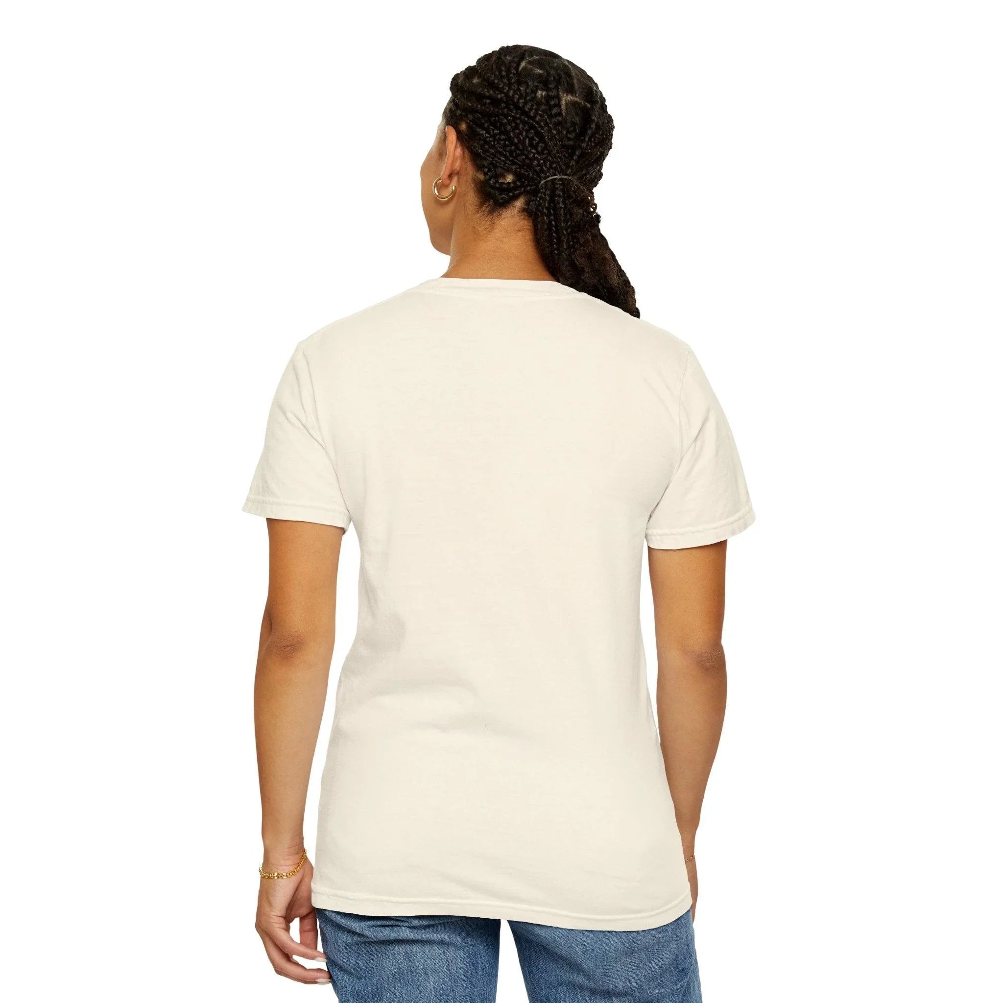 Woman wearing cream cotton t-shirt with braided hair, gold hoop earring, and blue jeans