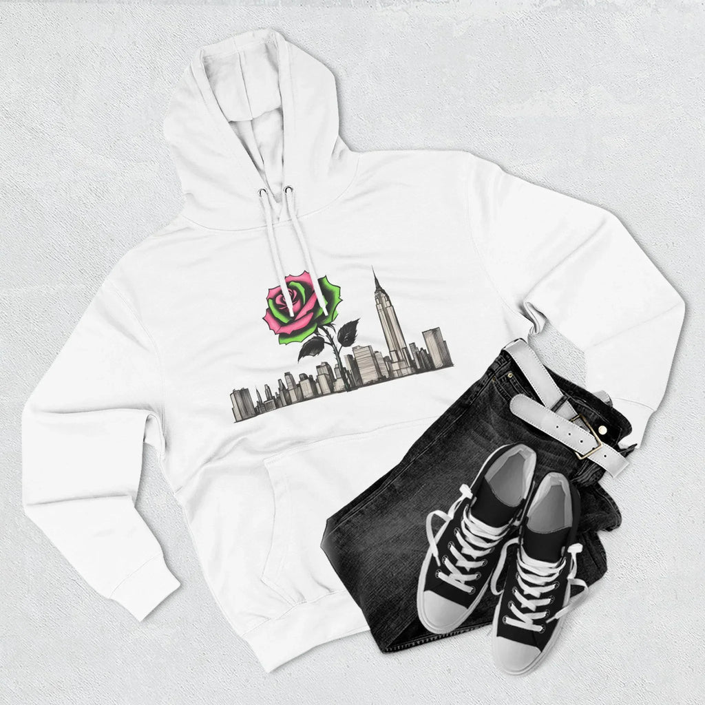 White hoodie with rose and city skyline graphic, paired with black jeans and sneakers