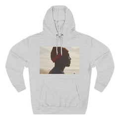 Light grey hoodie with a photo print of a person in profile wearing a red hat at the beach.
