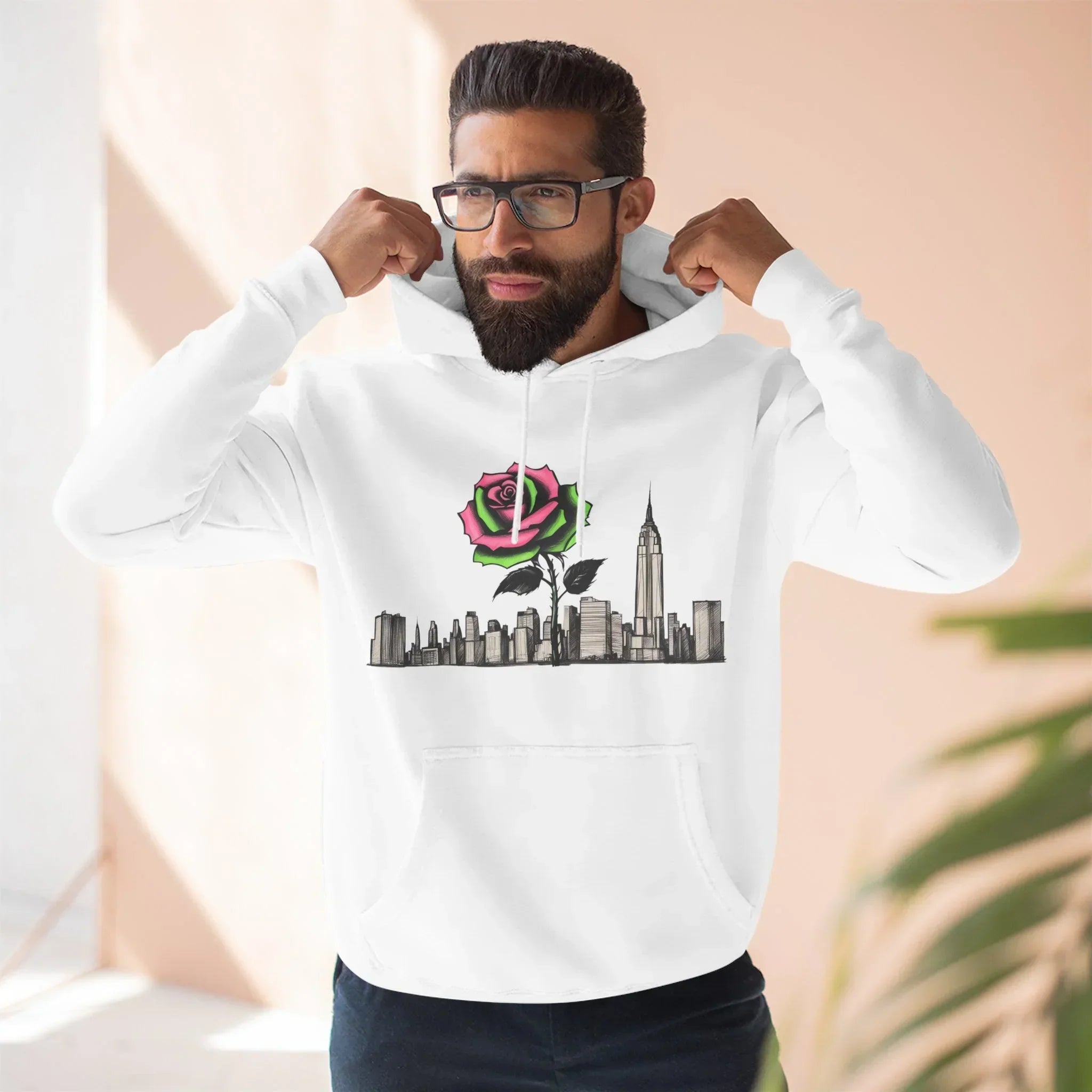 Man wearing white hoodie with New York City skyline and pink rose graphic design