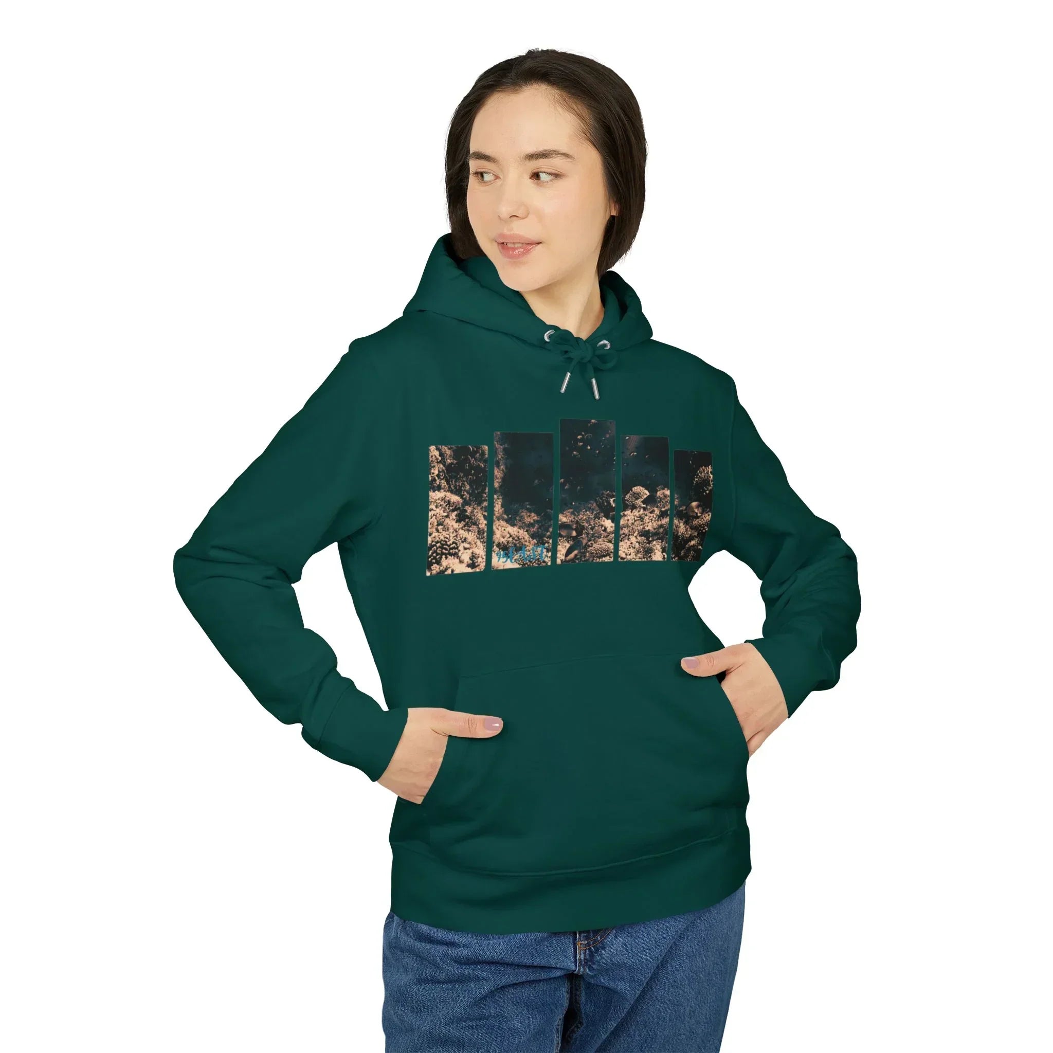 Woman wearing a dark green hoodie with nature-inspired graphic design, hands in pockets