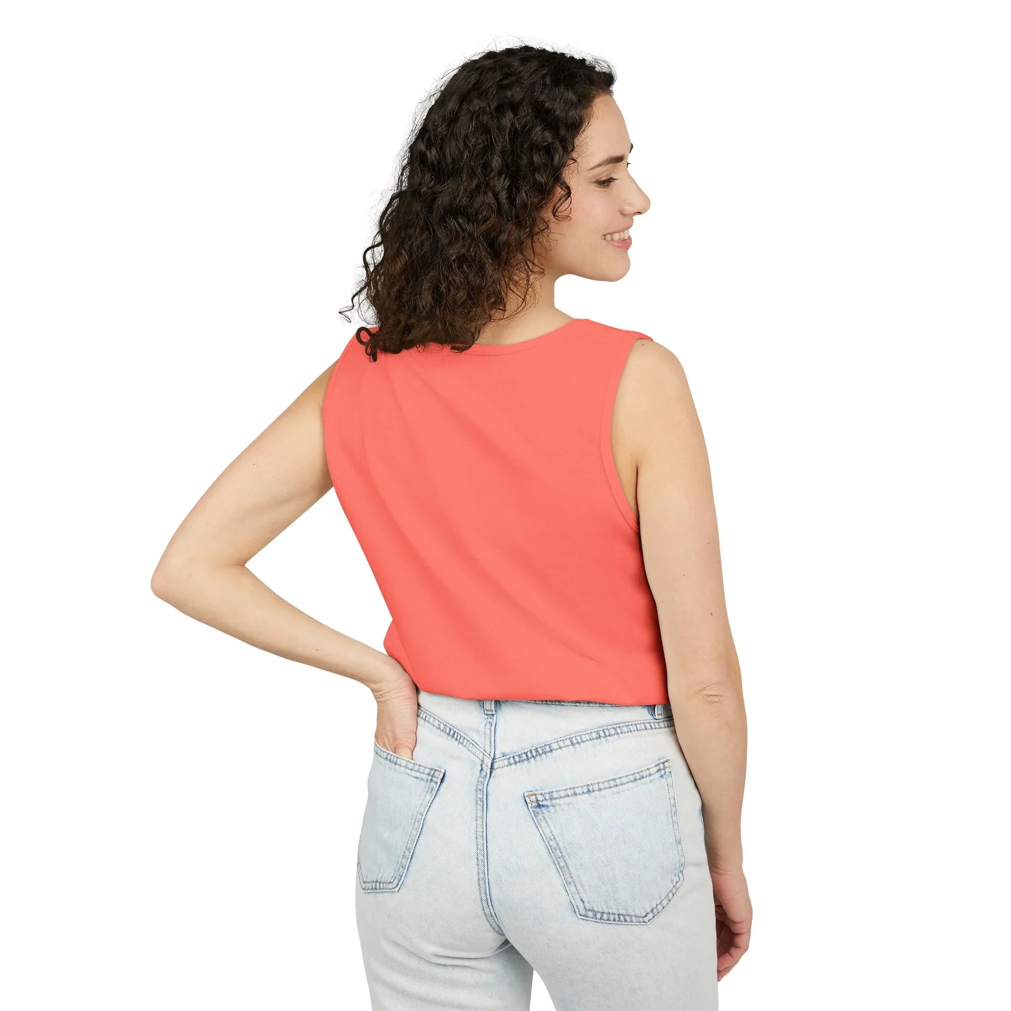 Woman in coral sleeveless top and light wash jeans, showcasing casual style