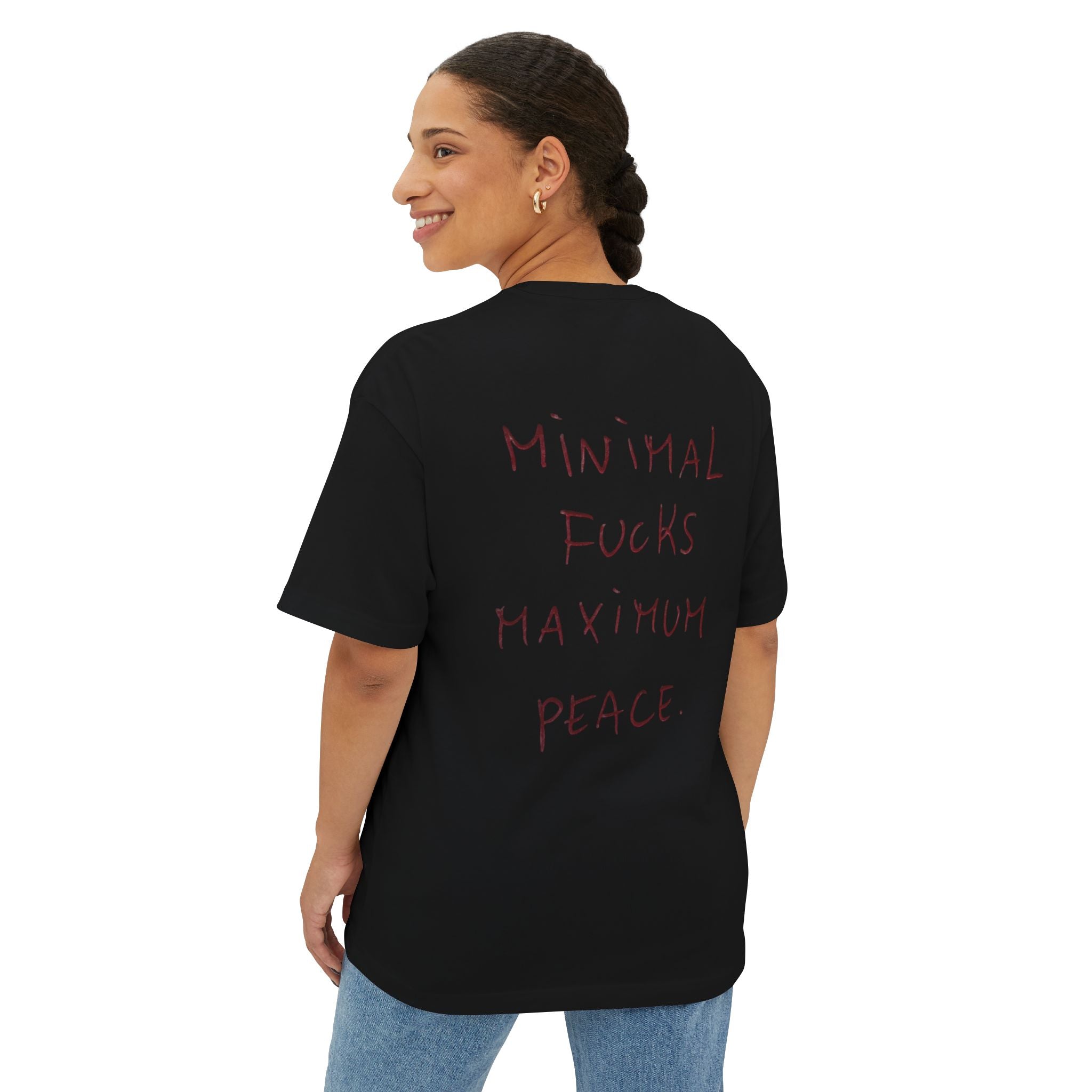 Black oversized t-shirt with red handwritten text: Minimal Fucks Maximum Peace, worn by woman