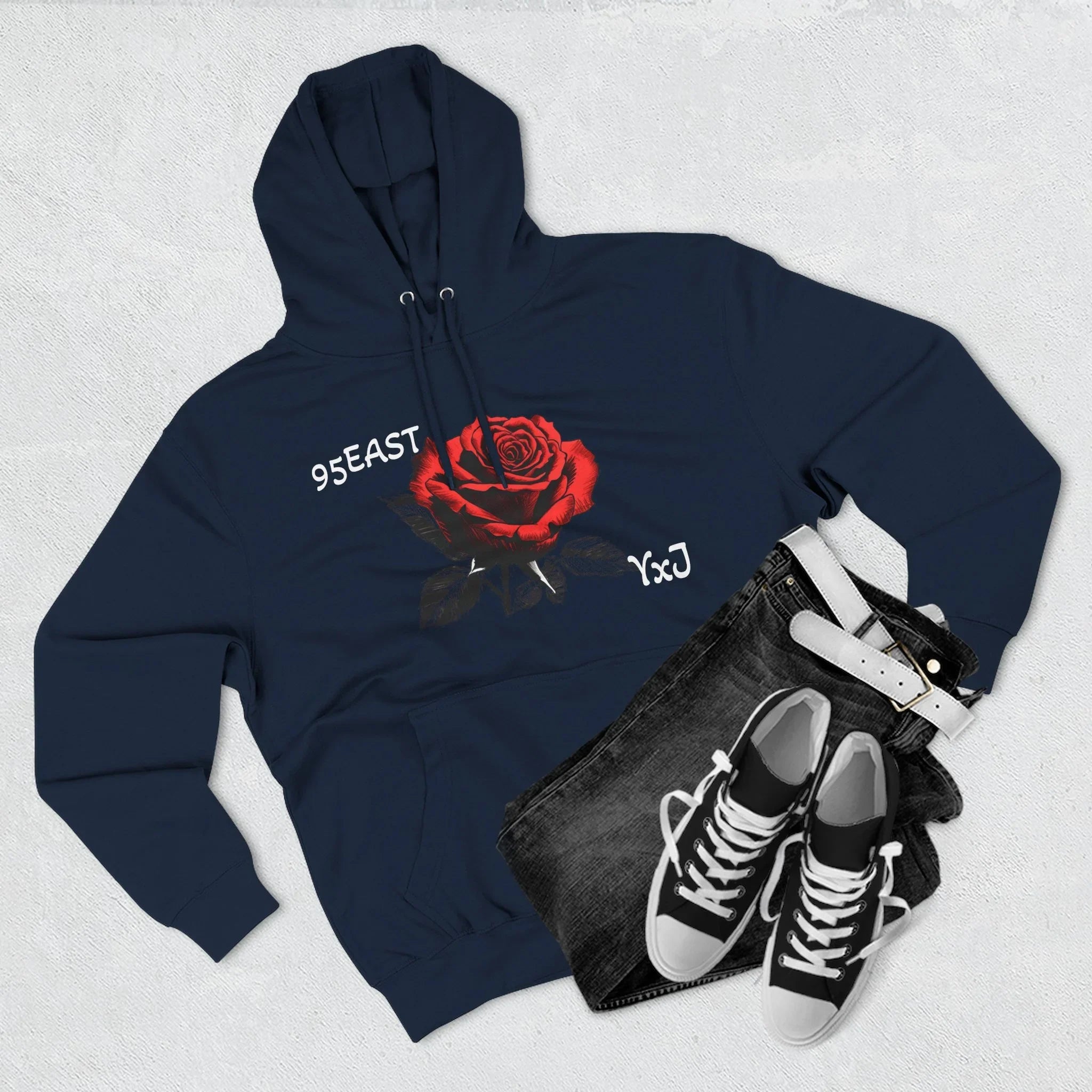 Navy hoodie with red rose graphic and '95EAST YxJ' text, styled with jeans and sneakers