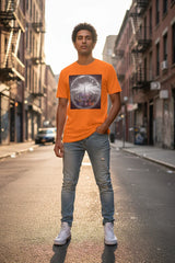 Man wearing orange graphic tee with NYC skyline, standing on urban street, casual streetwear style