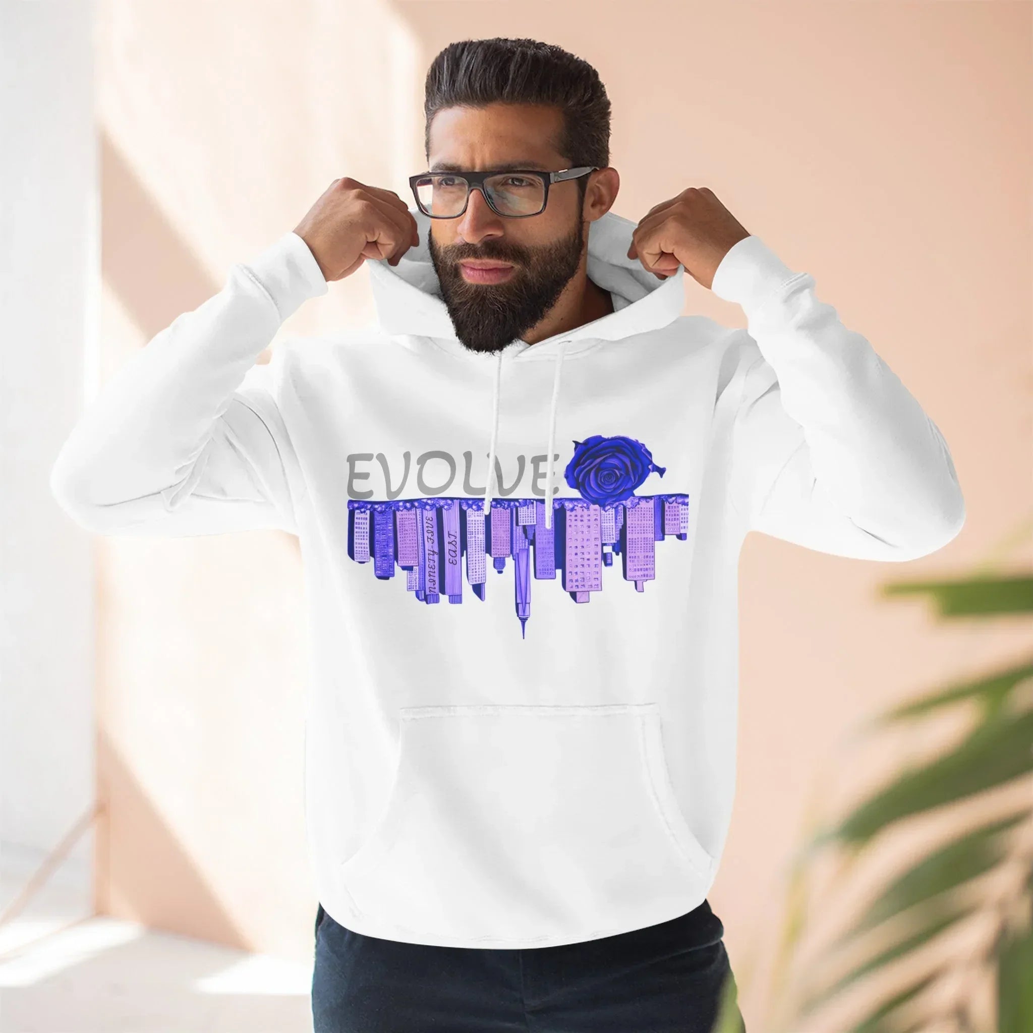 White hoodie with EVOLVE text, blue rose, and city skyline graphic, worn by man adjusting hood