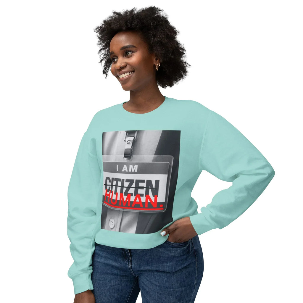 Smiling woman in aqua crewneck sweatshirt featuring bold 'I am human' graphic print