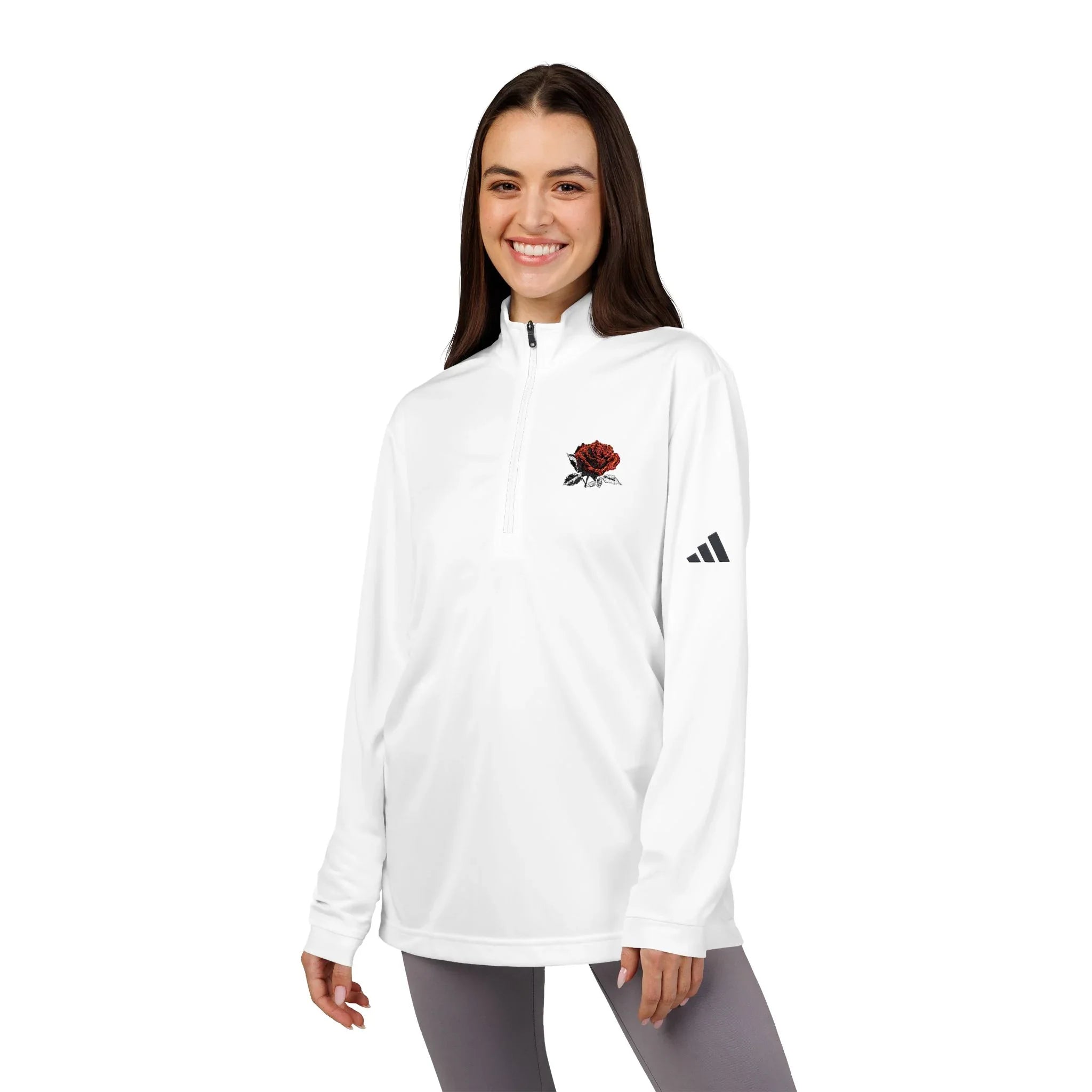 Smiling woman wearing a white quarter-zip pullover with red rose embroidery and black logo sleeve detail