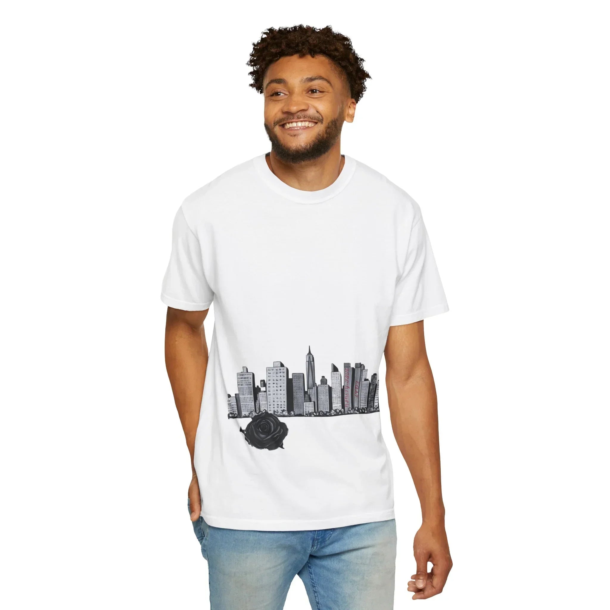 Man wearing white t-shirt with black city skyline and rose graphic, blue jeans, smiling