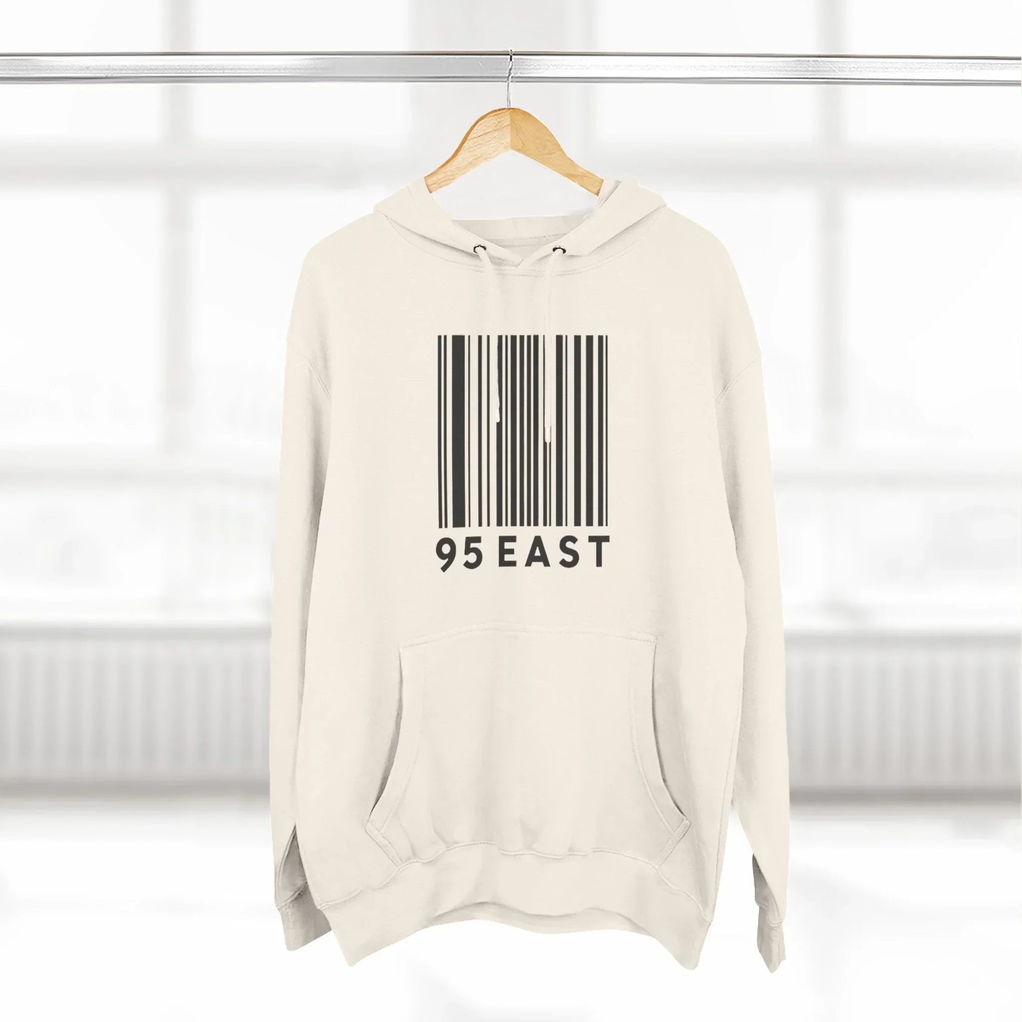 Cream hoodie with barcode design and 95 EAST text, modern East Coast style apparel