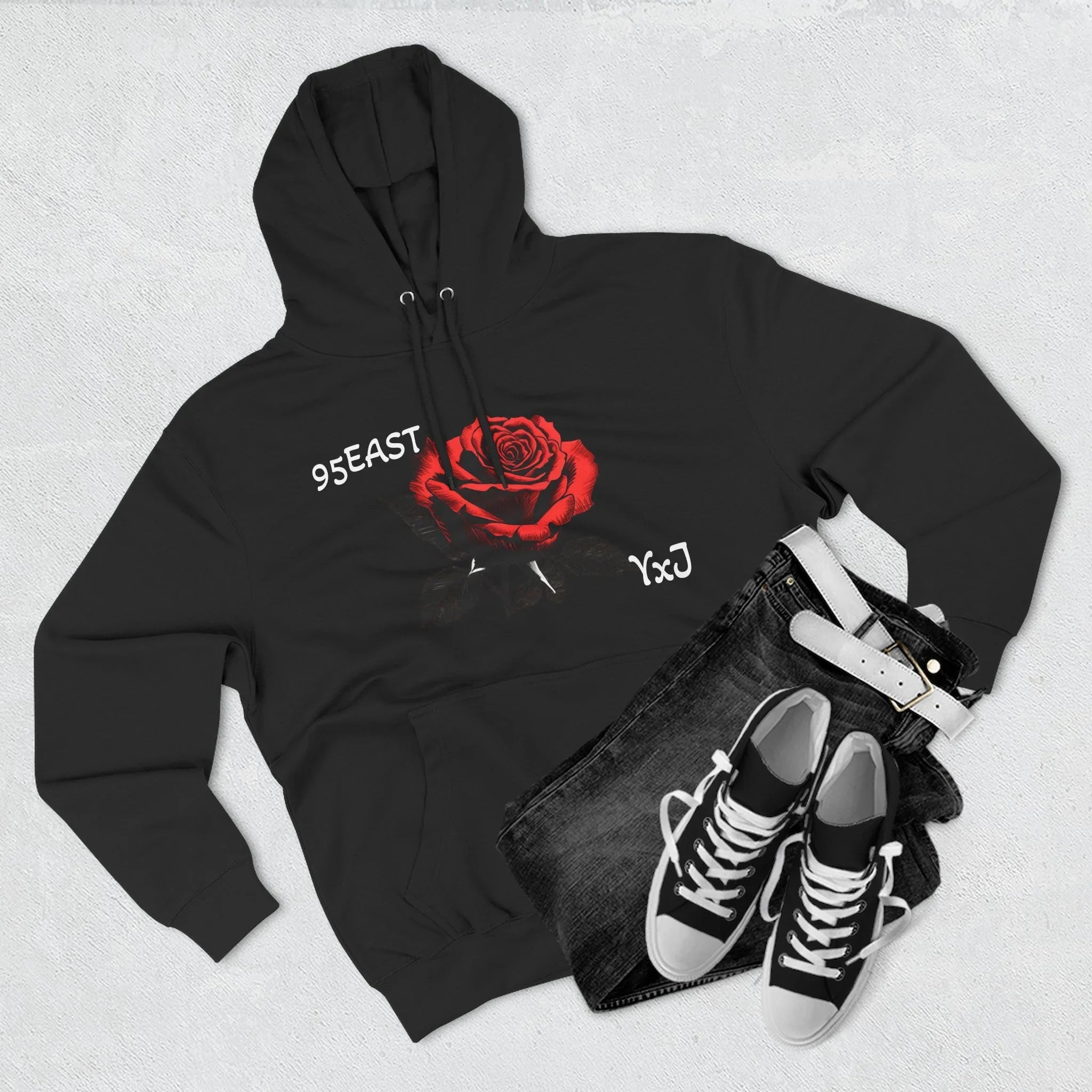 Black hoodie with red rose graphic and barcode sleeve detail, styled with jeans and sneakers