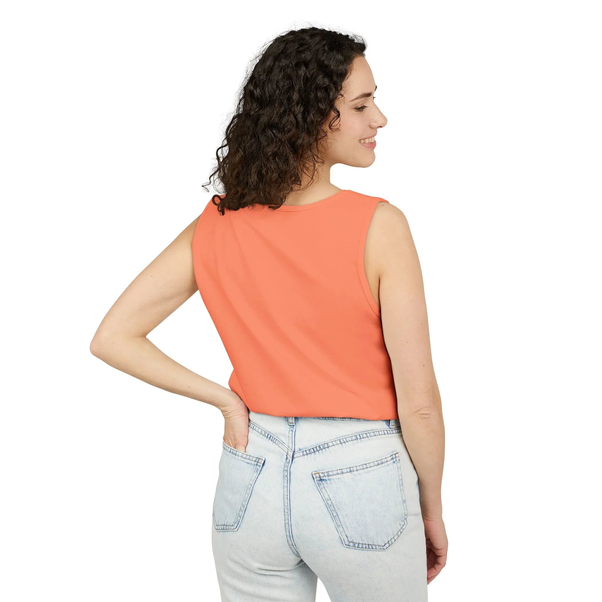 Woman in coral sleeveless top and light wash jeans, side view